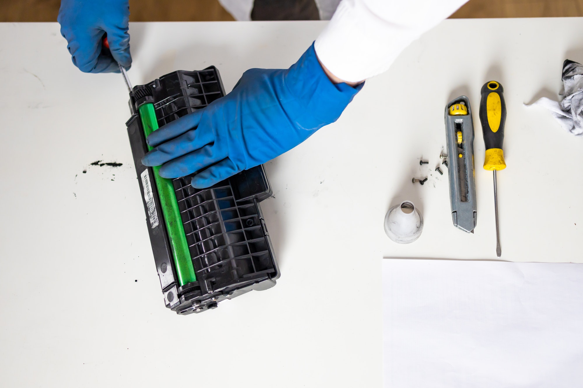 hands repairing laser toner cartridge. worker Laser printer on a workbench.